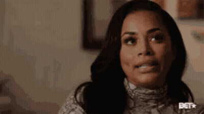 A Close Up Of A Woman 'S Face With A Snake Print Sweater On . GIF