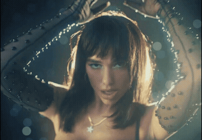 A Close Up Of A Woman 'S Face With A Star Necklace On Her Neck GIF