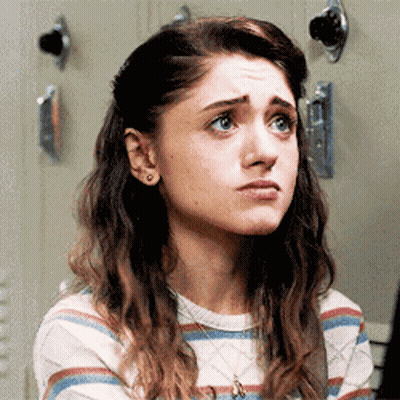 A Close Up Of A Woman 'S Face With A Striped Shirt And A Necklace . GIF