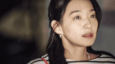 A Close Up Of A Woman 'S Face With A Striped Shirt On . GIF