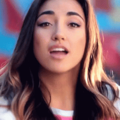 A Close Up Of A Woman 'S Face With A Striped Shirt On GIF