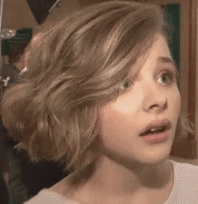A Close Up Of A Woman 'S Face With A Surprised Expression On Her Face . GIF