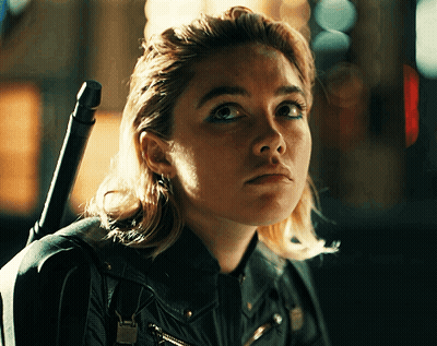 A Close Up Of A Woman 'S Face With A Sword On Her Shoulder GIF