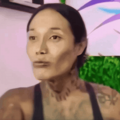A Close Up Of A Woman 'S Face With A Tattoo On Her Neck GIF