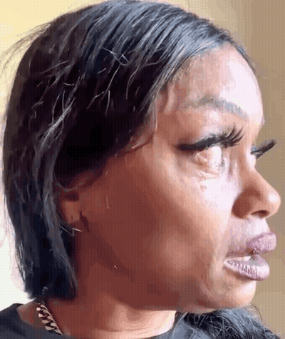 A Close Up Of A Woman 'S Face With A Tear Running Down Her Cheek . GIF
