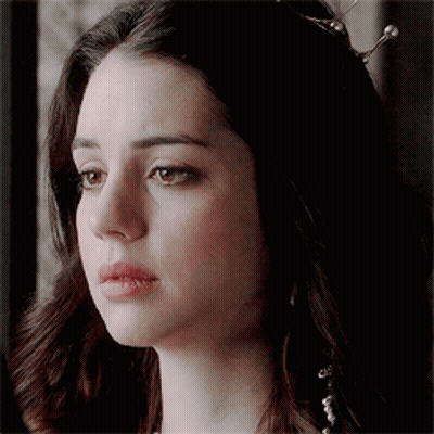 A Close Up Of A Woman 'S Face With A Tiara On Her Head . GIF