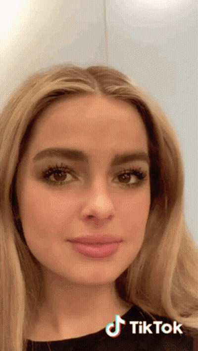 A Close Up Of A Woman 'S Face With A Tiktok Logo On The Bottom Right GIF