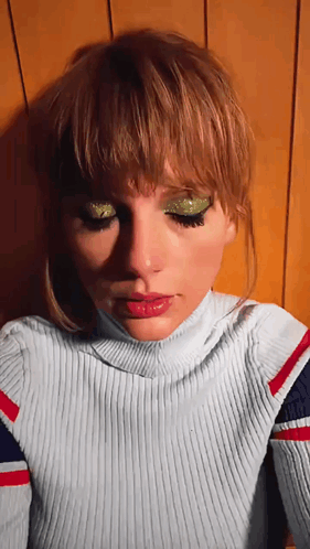 A Close Up Of A Woman 'S Face With A Turtleneck Sweater GIF