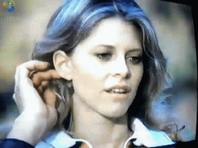 A Close Up Of A Woman 'S Face With A Tv Screen Behind Her That Says ' Cnn ' On It GIF