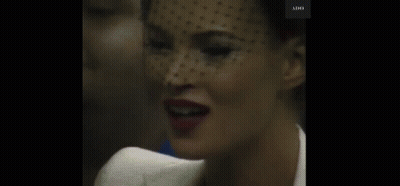 A Close Up Of A Woman 'S Face With A Veil On Her Head . GIF