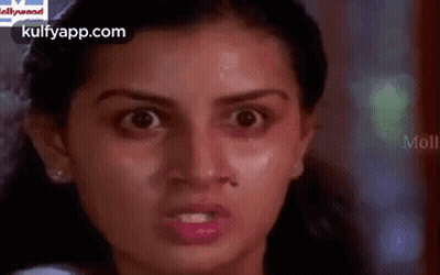 A Close Up Of A Woman 'S Face With A Very Angry Look On Her Face . GIF