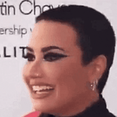 A Close Up Of A Woman 'S Face With A Very Short Haircut . GIF