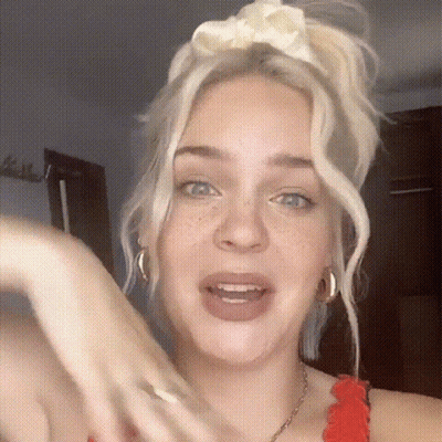 A Close Up Of A Woman 'S Face With A White Headband On Her Head . GIF
