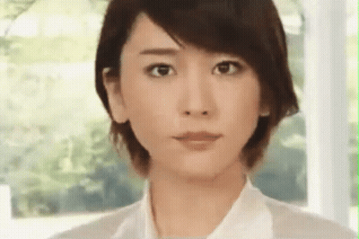 A Close Up Of A Woman 'S Face With A White Shirt On . GIF