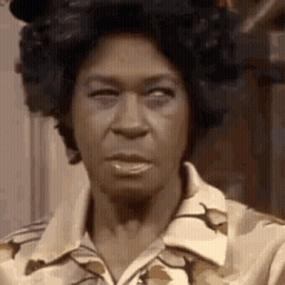 A Close Up Of A Woman 'S Face With A Wig On . GIF