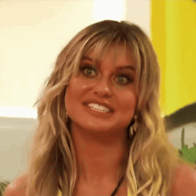 A Close Up Of A Woman 'S Face With A Yellow Background Making A Funny Face . GIF
