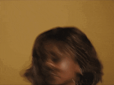 A Close Up Of A Woman 'S Face With A Yellow Background . GIF