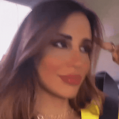 A Close Up Of A Woman 'S Face With A Yellow Top On GIF