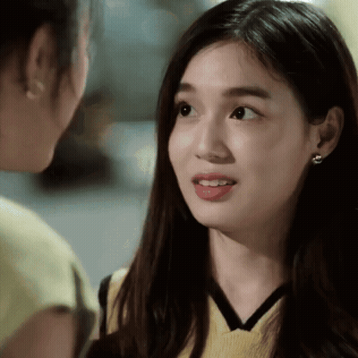 A Close Up Of A Woman 'S Face With A Yellow Top On GIF