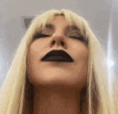 A Close Up Of A Woman 'S Face With Black Lips . GIF