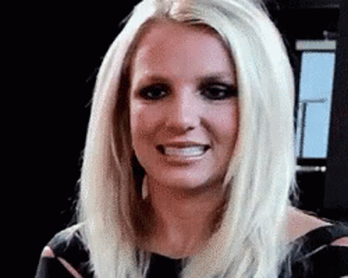 A Close Up Of A Woman 'S Face With Blonde Hair And A Black Dress . GIF