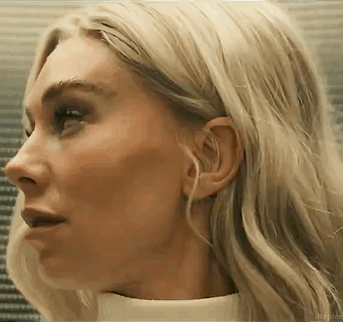 A Close Up Of A Woman 'S Face With Blonde Hair And A White Shirt . GIF