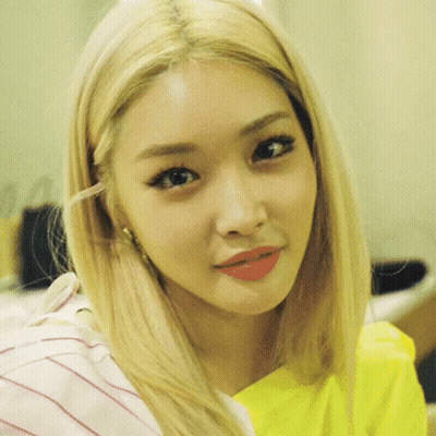 A Close Up Of A Woman 'S Face With Blonde Hair And A Yellow Shirt . GIF
