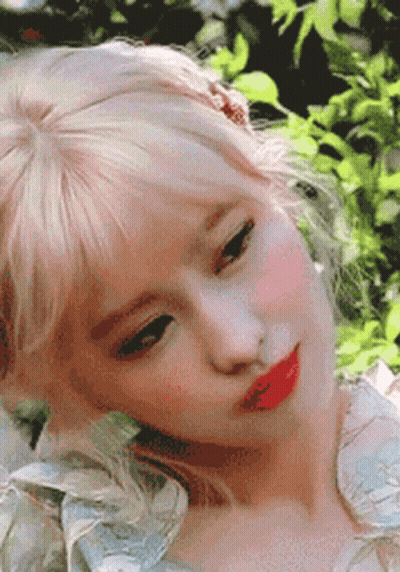 A Close Up Of A Woman 'S Face With Blonde Hair And Red Lips . GIF