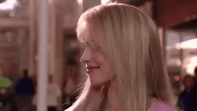 A Close Up Of A Woman 'S Face With Blonde Hair In A Pink Shirt . GIF