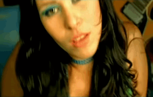 A Close Up Of A Woman 'S Face With Blue Eye Shadow And A Choker . GIF