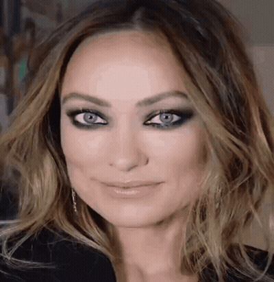 A Close Up Of A Woman 'S Face With Blue Eyes . GIF
