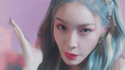 A Close Up Of A Woman 'S Face With Blue Hair And Pink Lipstick . GIF