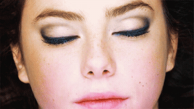 A Close Up Of A Woman 'S Face With Closed Eyes GIF