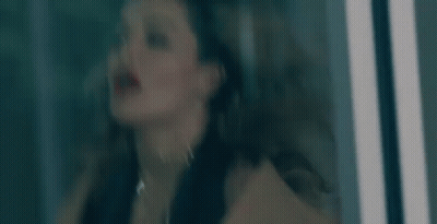 A Close Up Of A Woman 'S Face With Curly Hair . GIF