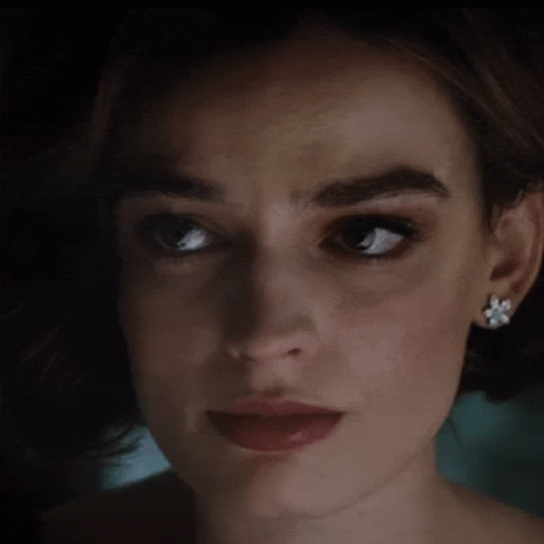 A Close Up Of A Woman 'S Face With Earrings GIF