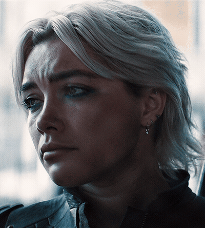 A Close Up Of A Woman 'S Face With Earrings On GIF