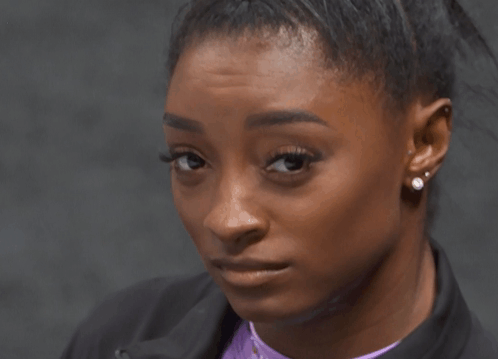 A Close Up Of A Woman 'S Face With Earrings On Her Ears GIF
