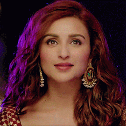 A Close Up Of A Woman 'S Face With Earrings On GIF