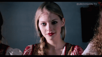 A Close Up Of A Woman 'S Face With Eurovision.tv In The Upper Right Corner GIF