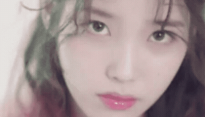 A Close Up Of A Woman 'S Face With Green Hair And Pink Lipstick . GIF