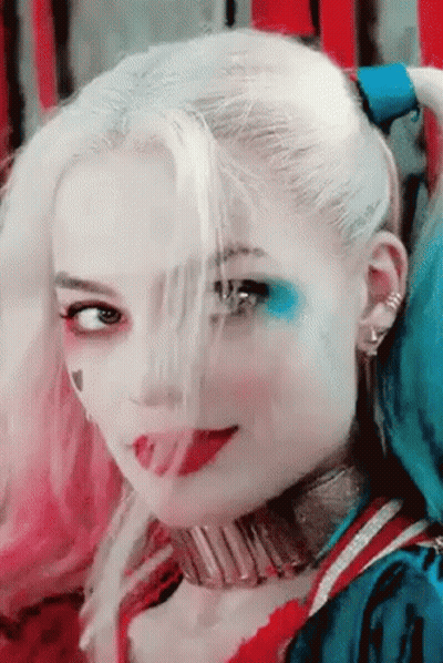 A Close Up Of A Woman 'S Face With Harley Quinn Makeup GIF