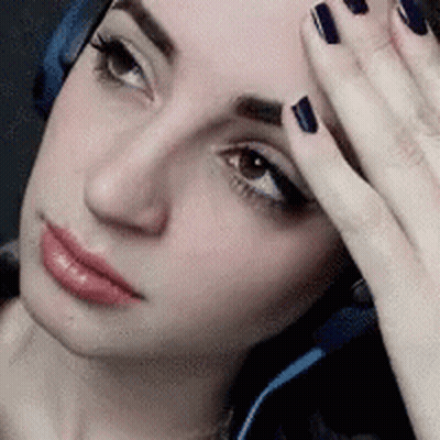 A Close Up Of A Woman 'S Face With Headphones On GIF