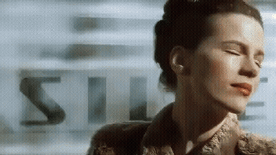A Close Up Of A Woman 'S Face With Her Eyes Closed And A Blurry Background . GIF