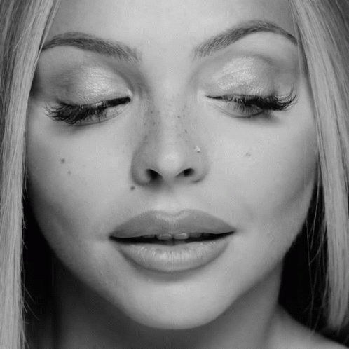 A Close Up Of A Woman 'S Face With Her Eyes Closed And A Nose Ring GIF