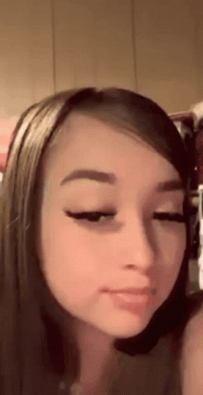 A Close Up Of A Woman 'S Face With Her Eyes Closed And A Piercing In Her Nose . GIF