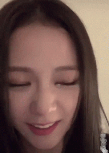 A Close Up Of A Woman 'S Face With Her Eyes Closed And A Smile On Her Face GIF