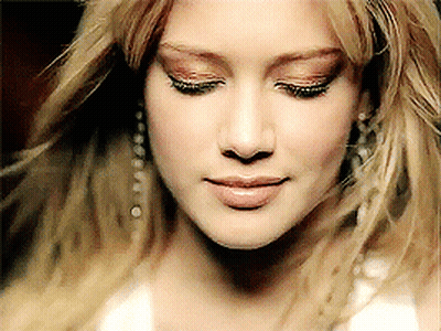 A Close Up Of A Woman 'S Face With Her Eyes Closed And Her Hair Blowing In The Wind GIF