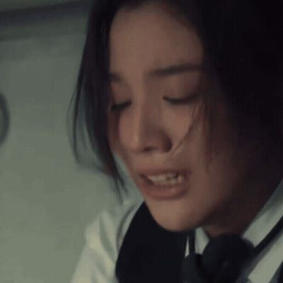 A Close Up Of A Woman 'S Face With Her Eyes Closed And Her Hair Blowing In The Wind GIF