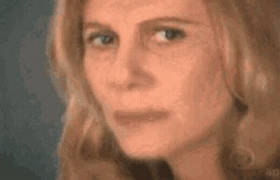 A Close Up Of A Woman 'S Face With Her Eyes Closed And Her Mouth Open . GIF