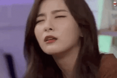 A Close Up Of A Woman 'S Face With Her Eyes Closed And Her Mouth Open . GIF